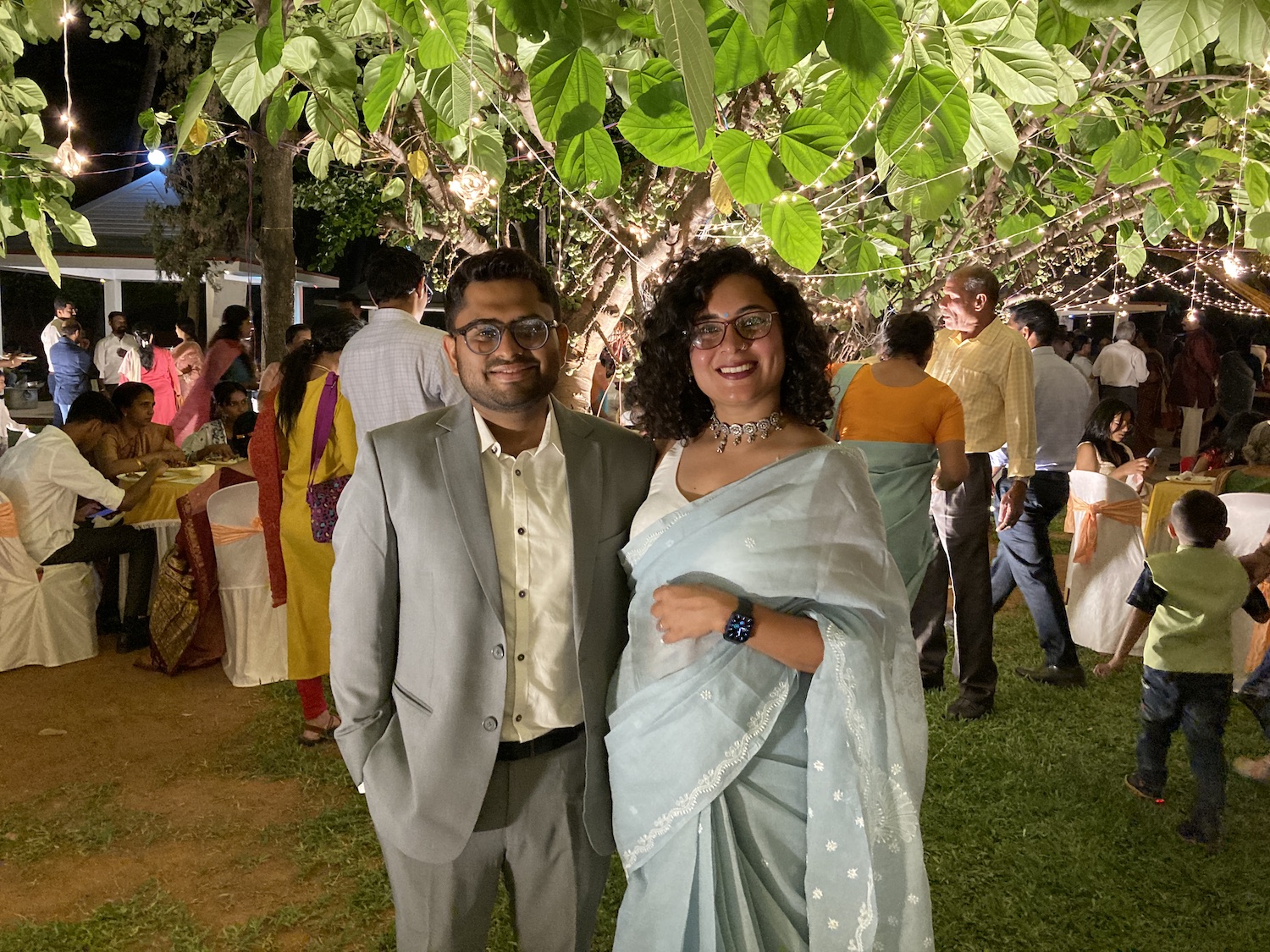 A couple posing for a photograph in front of a tree